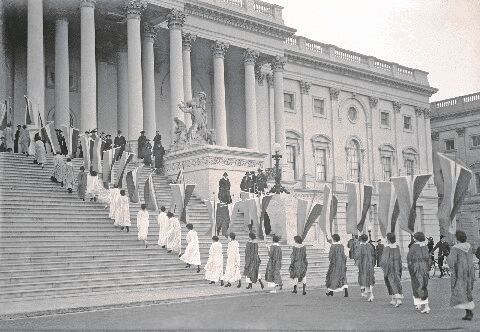Woman suffrage demonstrators with banners at the U.S. Capitol in 1917. View of procession ascending Capitol steps.